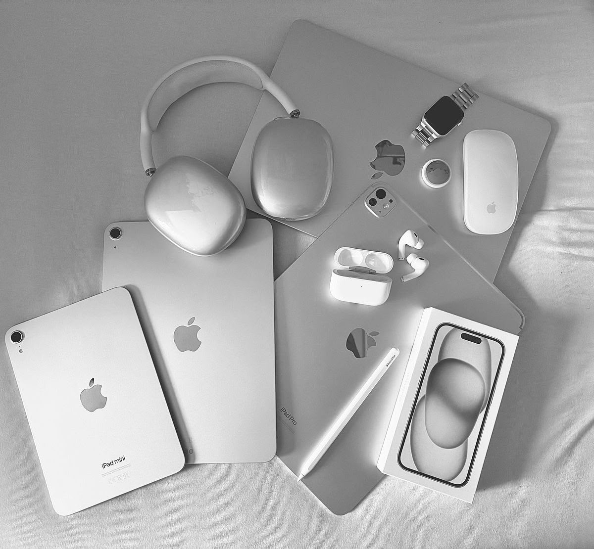 Produits Apple en noir et blanc : iPad, AirPods Max, MacBook, iPhone et Apple Watch